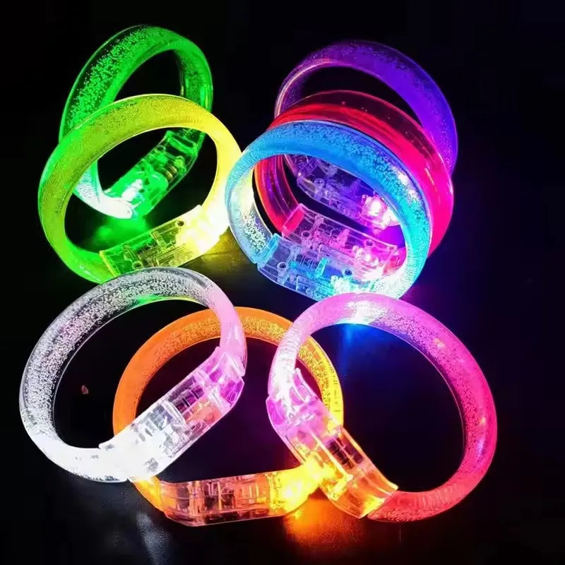 A collection of ten glowing LED flash bracelets in various colors including green, yellow, blue, and pink on a dark backgroun