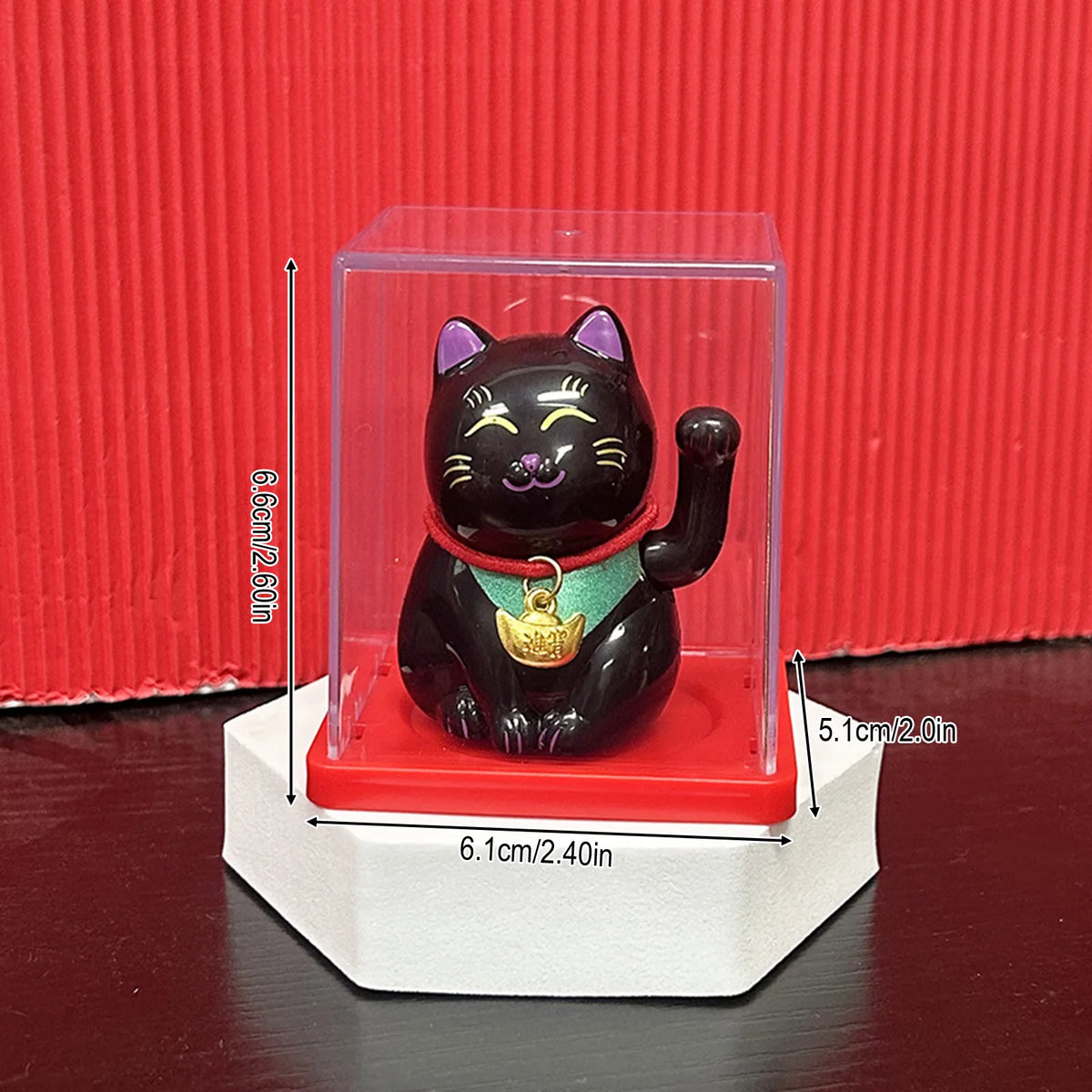 A black figurine of a cat with purple accents is displayed inside a clear box on a white stand.