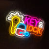Neon wall sign featuring a key and lock silhouette with bright yellow, pink, and blue lights.
