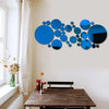 Abstract blue and black circular mirror decals displayed on a wall above a wooden table.