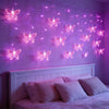 Purple bedroom wall decorated with hanging LED butterfly lights