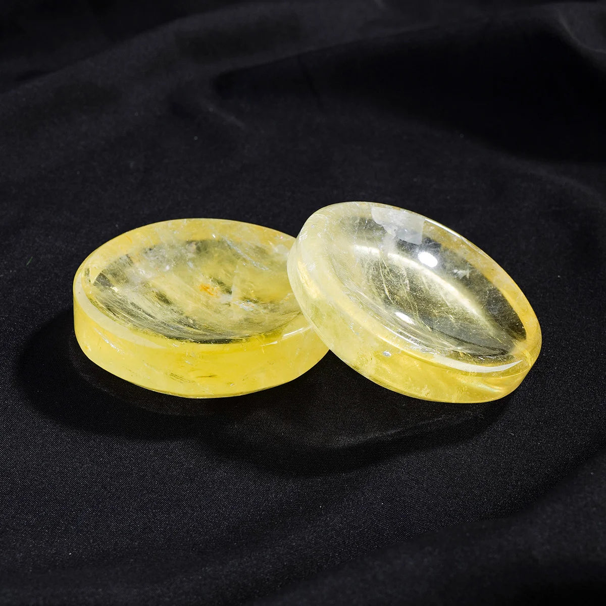 Two polished yellow citrine crystals resting on a dark surface.