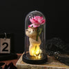 An eternal rose LED decorative flower with a pink rose and a teddy bear figurine displayed in a glass dome.