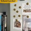 A display of gold star fridge magnets and a framed love quotes print on a light gray wall.