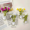 A collection of small glass jars filled with fresh greenery and flowers used for decoration.