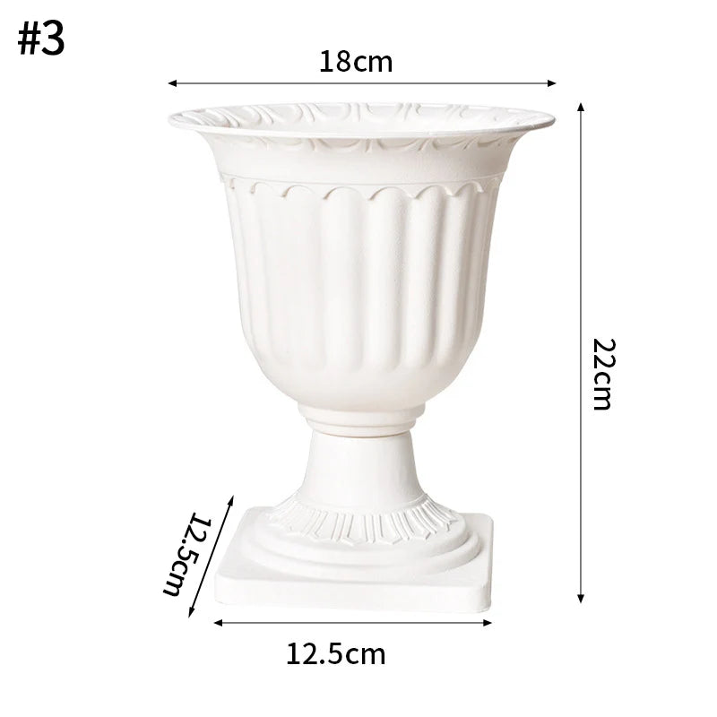 A white plastic decorative vase with a fluted body and pedestal base.