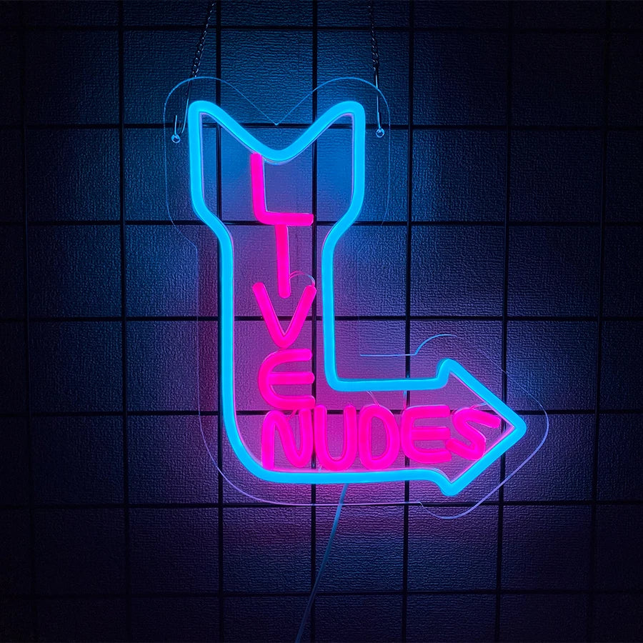 Neon wall sign shaped like an arrow with the text LIVE NUDES glowing bright pink and blue against a dark background