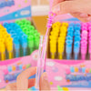 Une main presse un cadeau d'une fête (bulle) rose dans une boîte de tubes colorés.