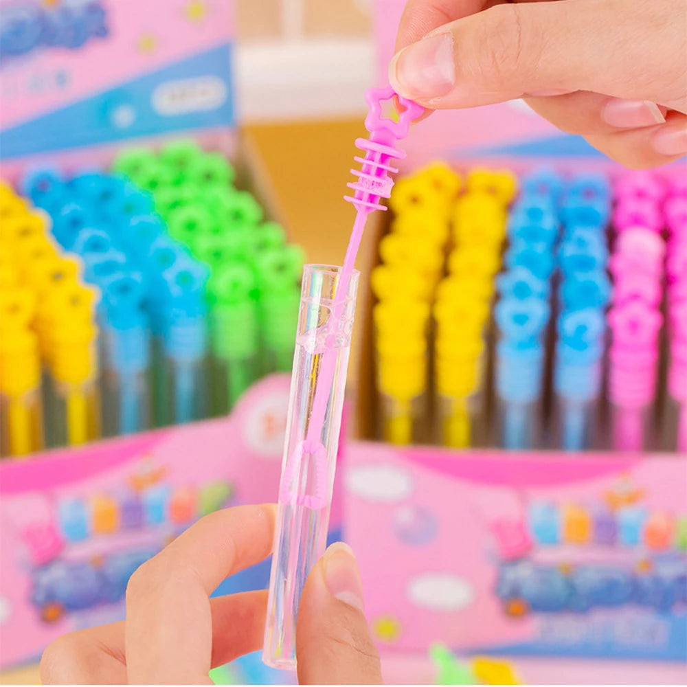 Une main presse un cadeau d'une fête (bulle) rose dans une boîte de tubes colorés.