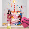 A colorful, abstract painting of a birthday cake with candles and paint splatters, featuring a young girl standing in front.