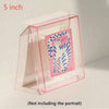 A clear acrylic photo frame with a pink border holds a colorful cat portrait inside.