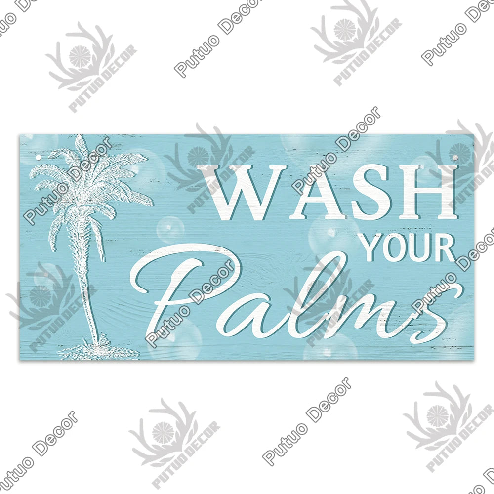 A light blue wooden sign with white text that reads WASH YOUR PALMS