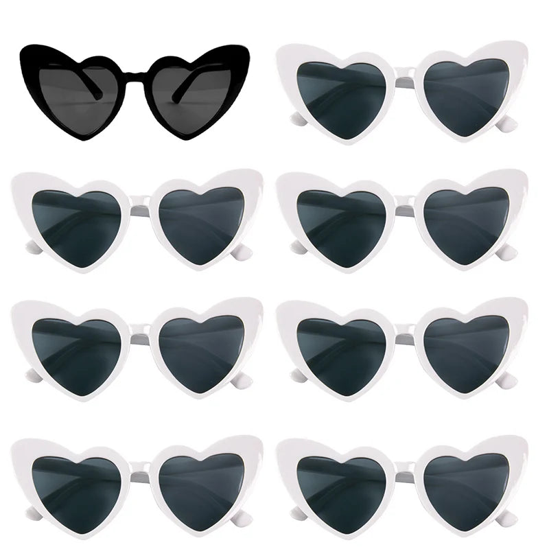 A set of heart-shaped sunglasses with black lenses and white frames.