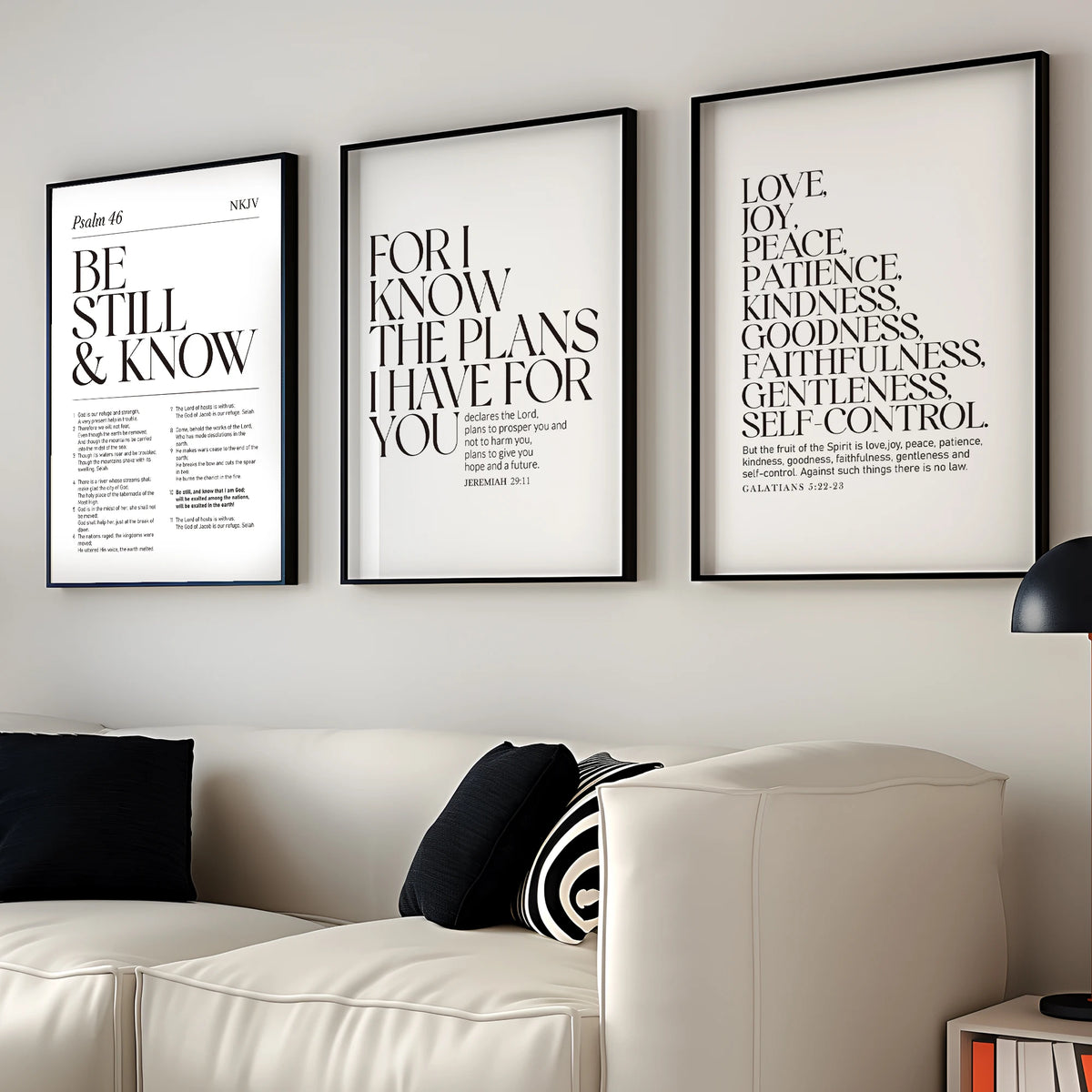Three framed Christian scripture prints featuring biblical verses on a white wall above a light-colored sofa.