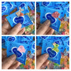 Hands hold a blue package of glow in the dark resin decor for fairy gardens