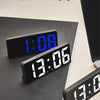 A black digital alarm clock displaying 1:08 on a dark surface.