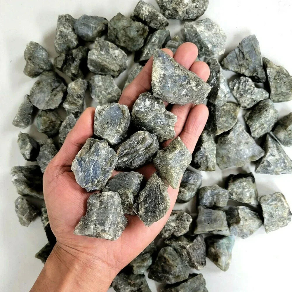 A hand holds a pile of natural raw healing crystal stones for chakra balancing and home decor