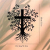 Black silhouette of a tree with roots and a cross cut out from a light-colored wall.