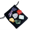 A set of natural crystal healing stones including purple, blue, red, and green stones tied with black string.