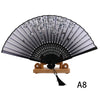 Black lace folding hand fan with silver accents displayed on a wooden stand.