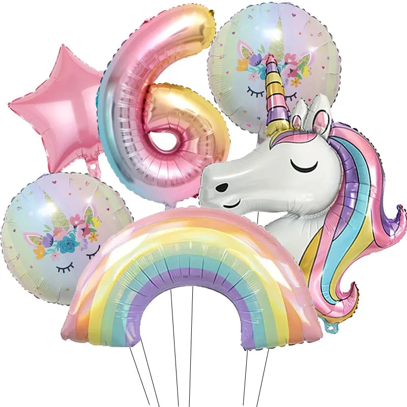 A collection of pink and iridescent foil balloons, including a number 6, a unicorn, and a rainbow arch.