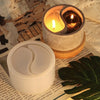 A silicone mold for yin yang tai chi used to create candlestick holders, resting on a piece of paper.