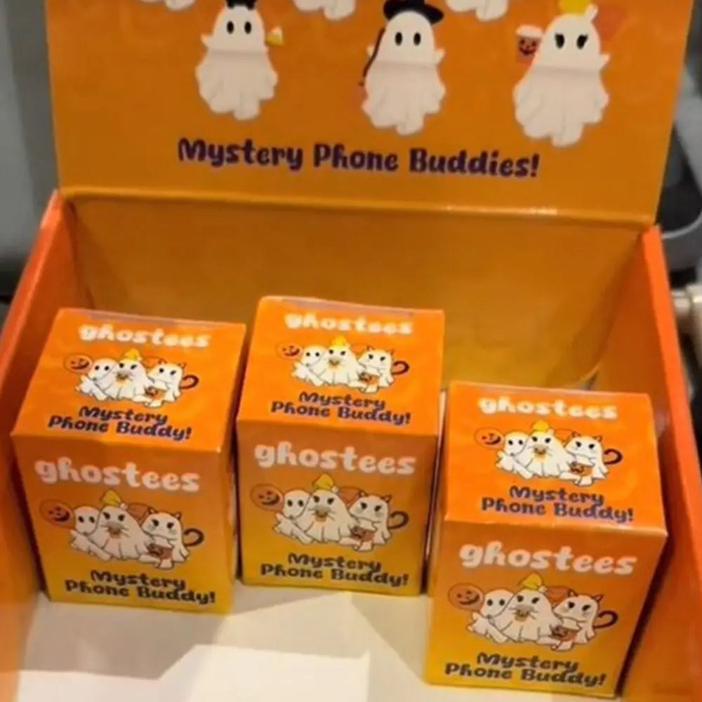 An orange box containing ghost phone buddy decorations and several individual ghost phone buddy charms.