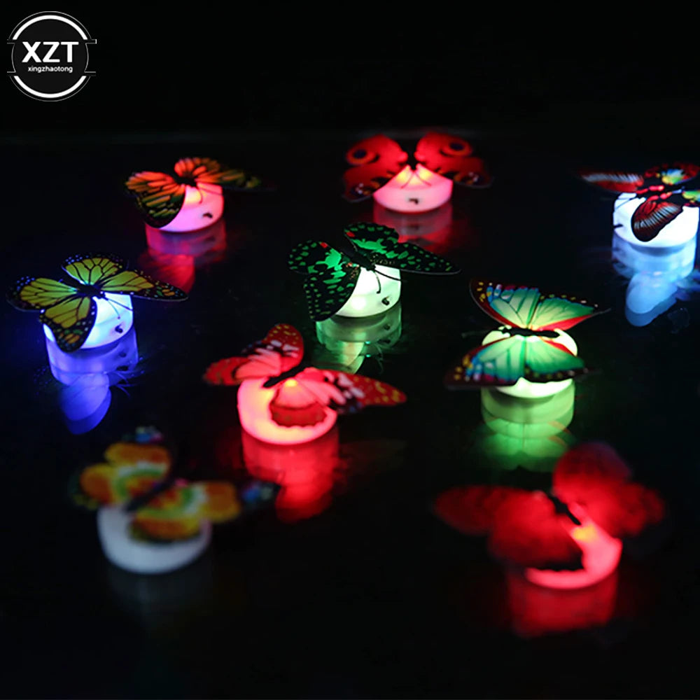 A collection of glowing 3D LED butterfly wall night lights floating on dark water.
