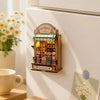 A wooden miniature florist shop display with flowers and an LED light, mounted on a white wall.