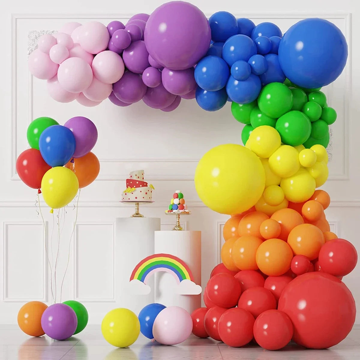A colorful balloon garland arch kit featuring pink, purple, blue, and green balloons arranged in an arc.