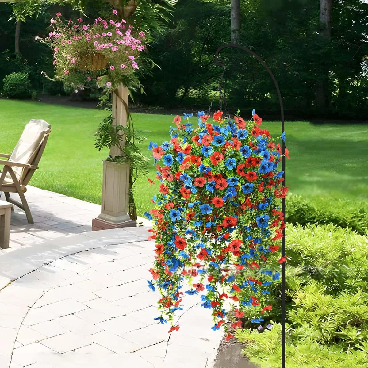 A hanging display of vibrant red, blue, and orange faux silk flowers in a garden setting.