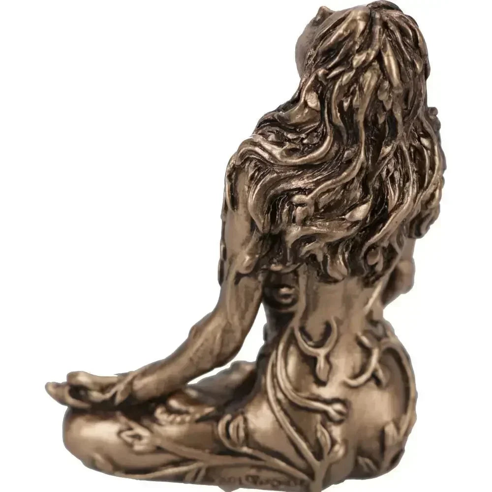 A bronze statue of a woman with long flowing hair in a meditative pose, representing Mother Earth Gaia.