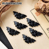 A set of black hand-carved obsidian bat figurines displayed on a light brown parchment background.