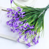 A bouquet of artificial purple calla lily flowers on a wooden frame.