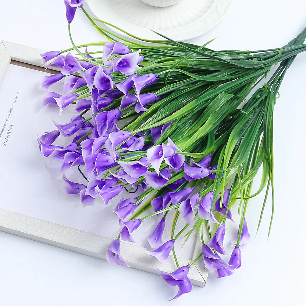 A bouquet of artificial purple calla lily flowers on a wooden frame.
