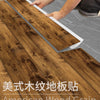 American wood grain floor stickers being installed on a wooden floor surface.