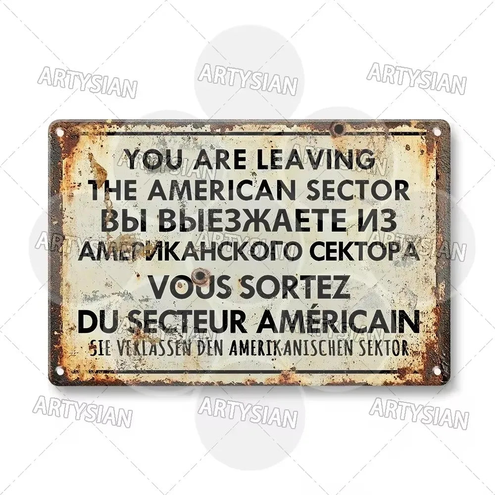 A vintage, rusted metal tin sign with text in English, Russian, and French announcing leaving the American sector.