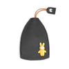 A black cartoon PU leather key holder with a yellow bunny charm and a leather pull-out loop.