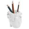 A white heart-shaped resin pen organizer filled with several colored pencils.