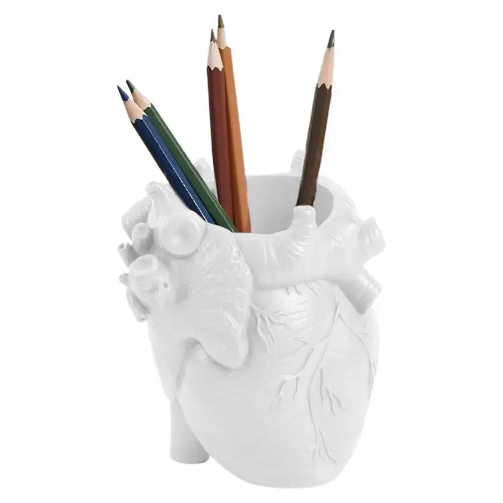 A white heart-shaped resin pen organizer filled with several colored pencils.