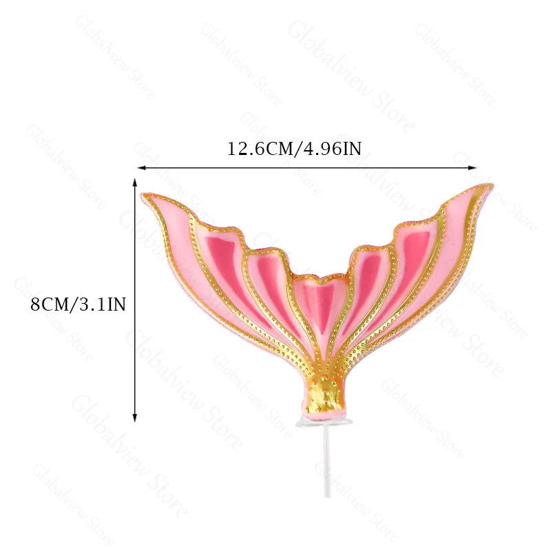 Pink mermaid tail cake topper featuring sea star and seashell decorations on a stick