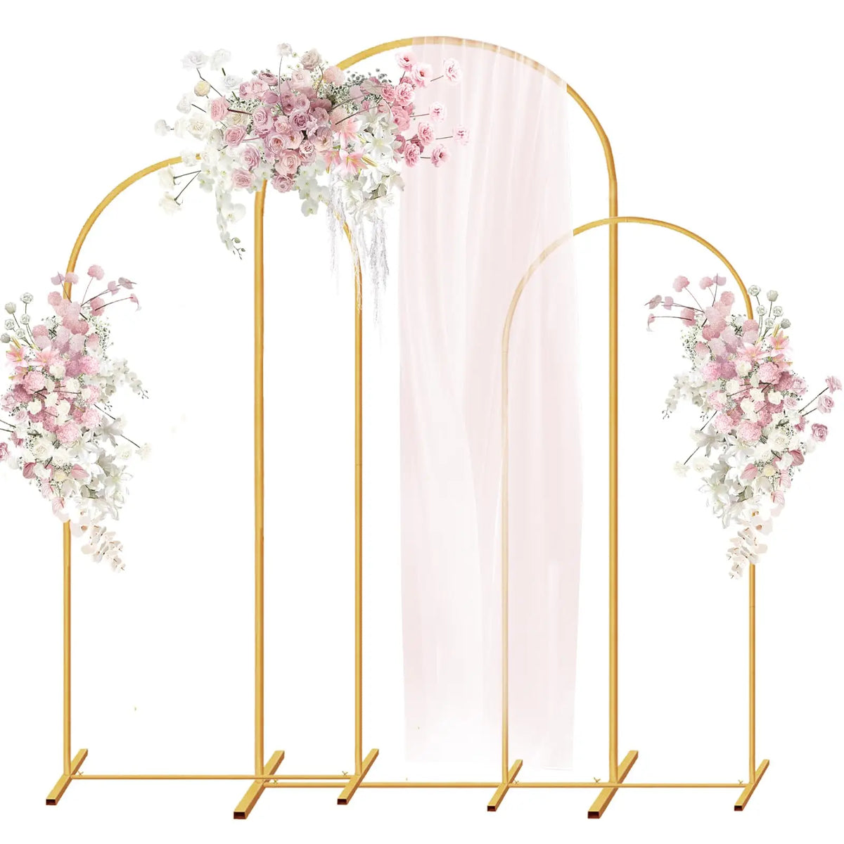 A set of three gold metal arched wedding backdrop stands with sheer pink draping.