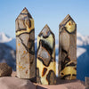 Trois points de cristal naturels de différentes tailles et couleurs, présentés sur une pierre.