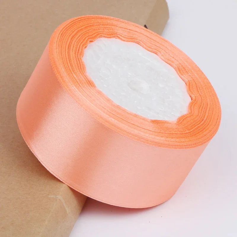 Roll of peach satin ribbon with white filling for crafts and gift wrapping