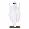 A white ghost decoration with round eyes hangs from a rope, displayed on a wooden plank.