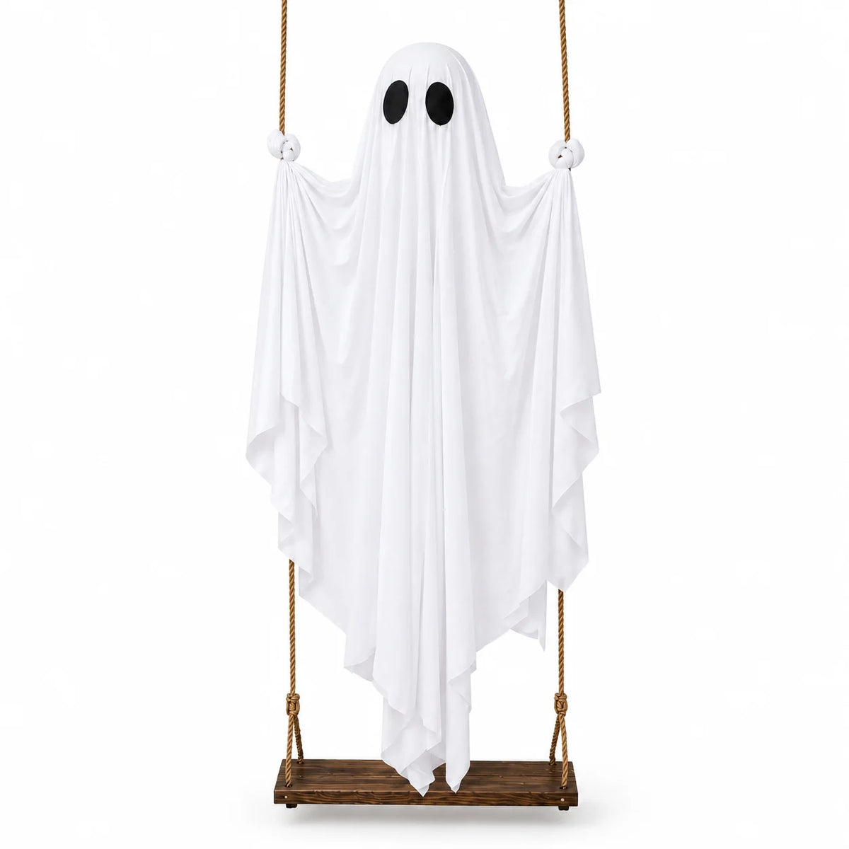 A white ghost decoration with round eyes hangs from a rope, displayed on a wooden plank.