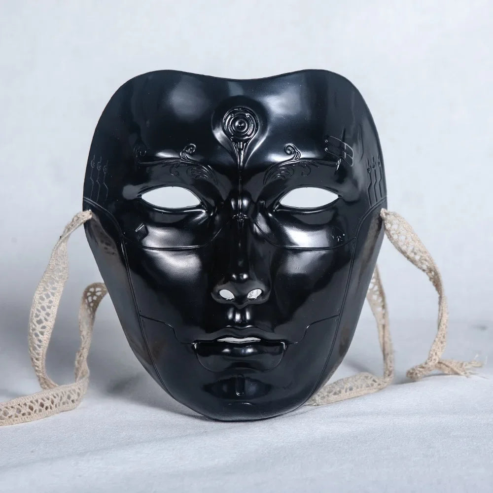 A black ancient style masquerade mask with intricate details and light beige ties.