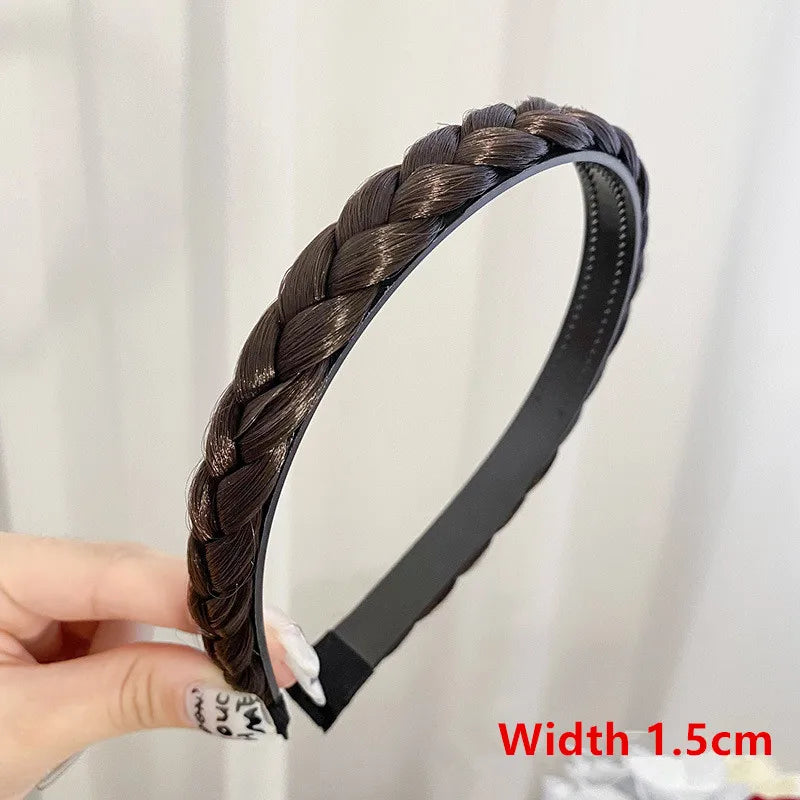 A black leather hair band with a braided texture is held by a hand.