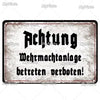 A vintage metal tin sign with black text that reads Achtung Wehrmachtanlagen betreten verboten