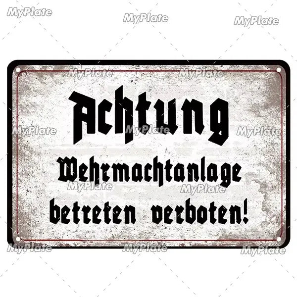 A vintage metal tin sign with black text that reads Achtung Wehrmachtanlagen betreten verboten